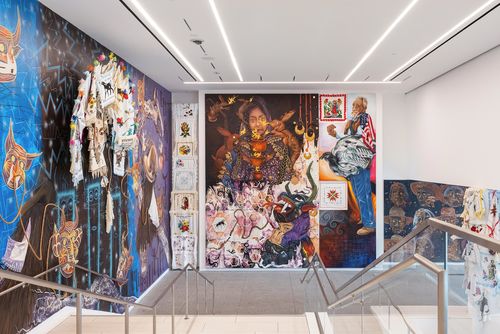 View of a museum lobby, walls covered in colorful murals