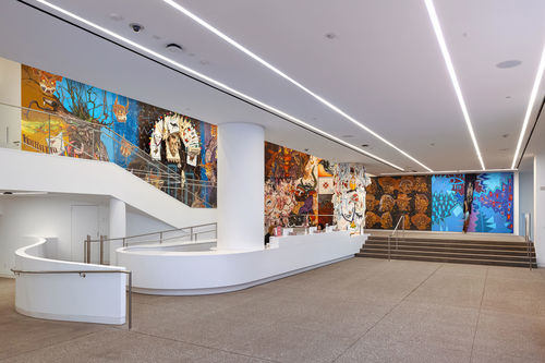 View of a museum lobby, walls covered in colorful murals