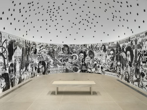 Vault installation featuring a floor-to-ceiling ceramic mural with black-and-white graphics, text, and images of people