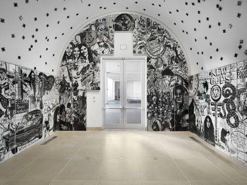 Vault installation featuring a floor-to-ceiling ceramic mural with black-and-white graphics, text, and images of people