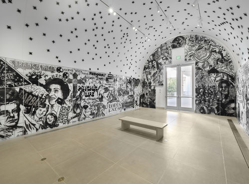 Vault installation featuring a floor-to-ceiling ceramic mural with black-and-white graphics, text, and images of people