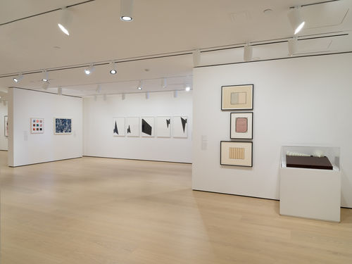 Gallery with framed works on paper on the wall