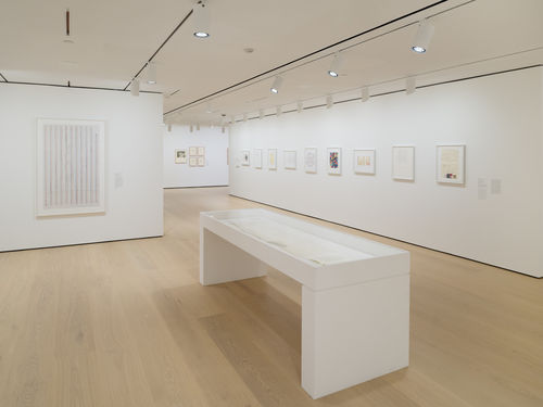 Gallery with framed works on paper on the wall