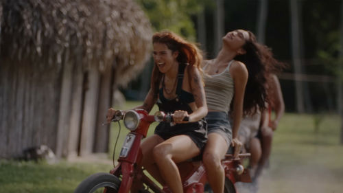 Still from a music video depicting two figures on a motorcycle