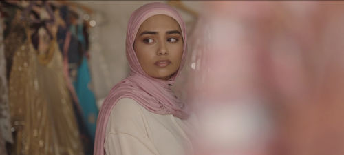 A figure wearing a pink hijab