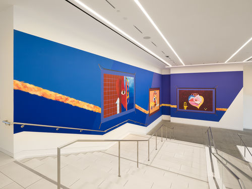 Mural on a bright blue background, installed along a large museum stairway