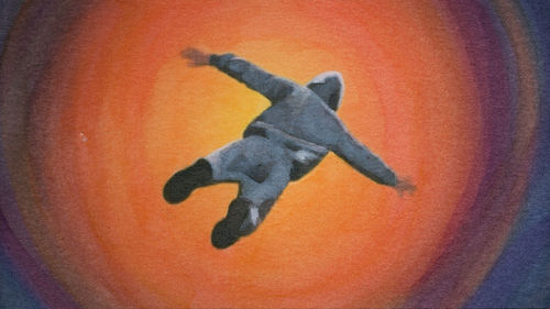 A figure in a hoody floats above an orange abyss