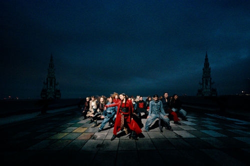 A group of women in formation, dancing in a spotlight