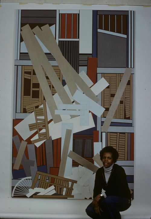 Artist Mavis Pusey crouches in front of a large vertical painting