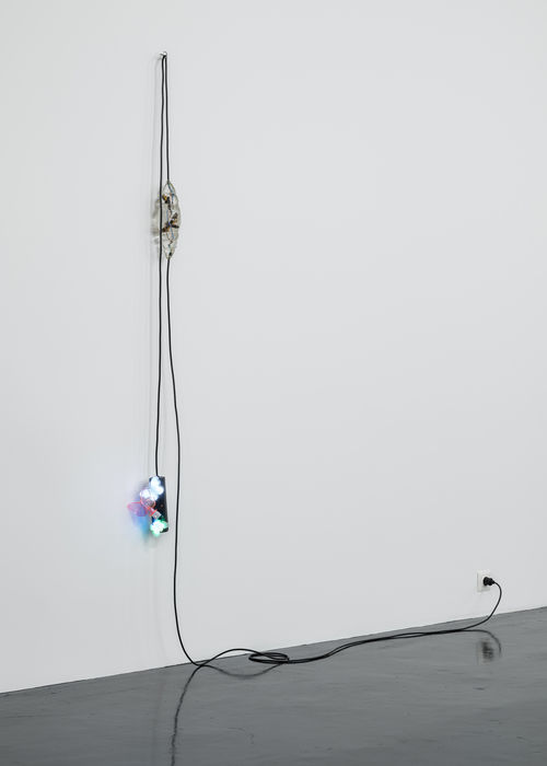 A black extension cord hangs from a wall, with three butterfly nightlights plugged into it