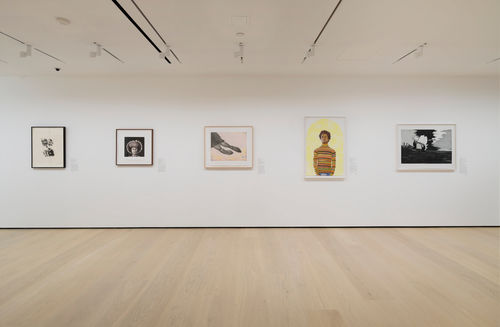 Gallery with framed works on paper mounted on the wall