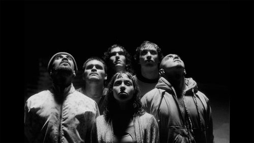 Photograph six figures in black-and-white looking upwards