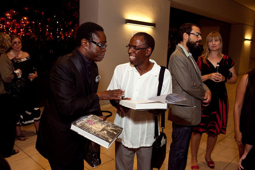 Artist Charles Gaines (right) signs an exhibition catalogue at the opening of "Now Dig This!" Hammer Museum, Los Angeles