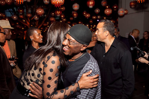 Artist John Outterbridge embraces a guest at the opening of "Now Dig This!" Actor Roger Guenveur Smith stands behind him. Hammer Museum, Los Angeles