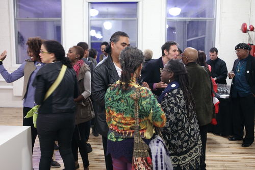 Guests in gallery during the opening reception for "Now Dig This!" Ian White, son of "Now Dig This!" artist Charles White, stands at center. MoMA PS1, Long Island City, NY