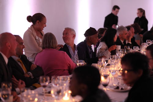 Curator Kellie Jones (standing) talks to PS1 Director Klaus Biesenbach at the dinner reception honoring "Now Dig This!" MoMA PS1, Long Island City, NY