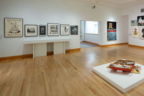 Foreground: Dan Concholar, "Suitcase," c. 1980; background: various posters and ephemera, Raymond Saunders, "American Dream," 1968. Installation view at Williams College Museum of Art, Williamstown, MA