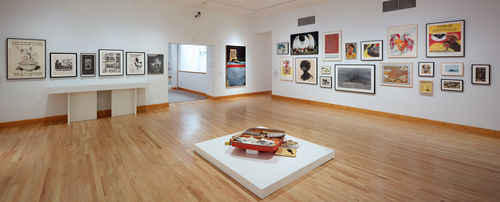 Foreground: Dan Concholar, "Suitcase," c. 1980; back wall: various posters and ephemera, Raymond Saunders, "American Dream," 1968; right wall: works by William Pajaud, Sister Karen Boccalero, Elizabeth Leigh-Taylor, Dan Concholar, Alonzo Davis, Andrew Zermeño, Sheila Levrant de Bretteville, Tyrus Wong, and Samella Lewis. Installation view at Williams College Museum of Art, Williamstown, MA