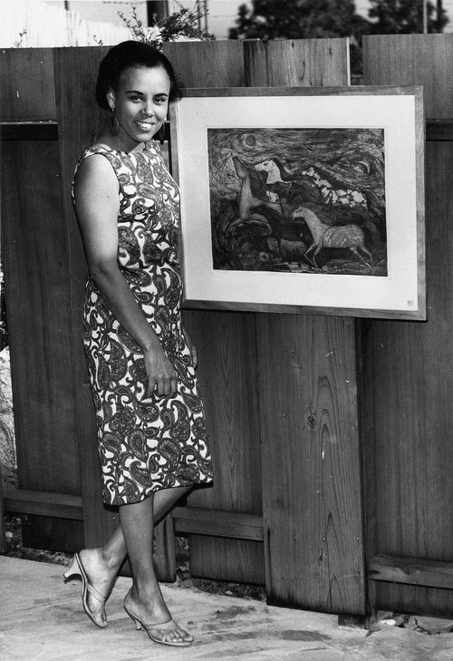Betye Saar with one of her artworks at a group exhibition at the home of Alvin and Jeffalyn Johnson in Altadena, California, June 1962