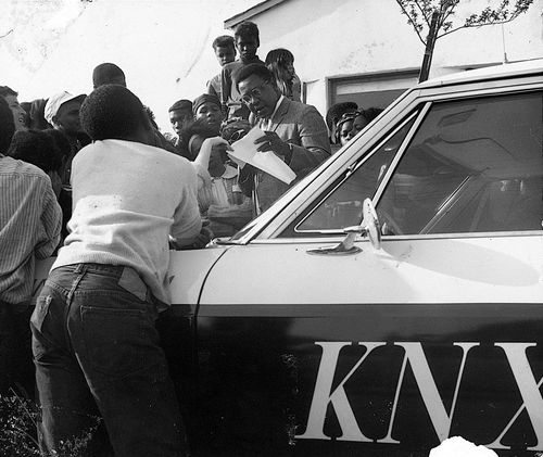 A reporter from KNX Radio covering "Operation Teacup," an Easter week cleanup organized by the Student Committee for Improvement in Watts, at the Watts Towers Arts Center