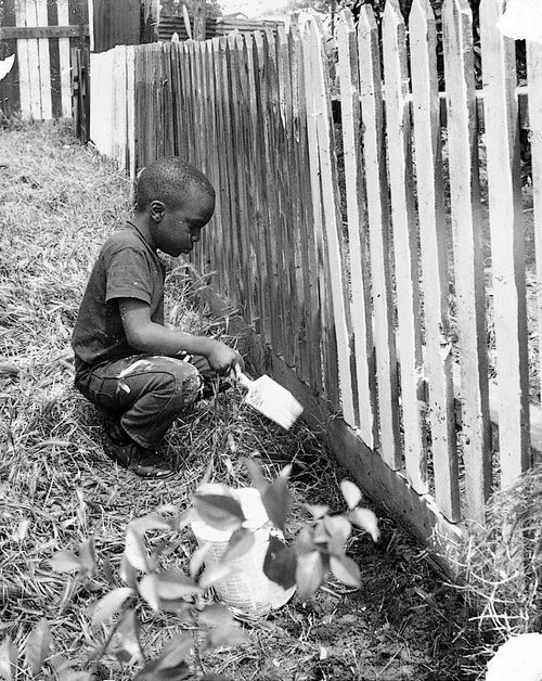 Young boy painting gate on 107th Street at "Operation Teacup," an Easter week cleanup organized by the Student Committee for Improvement in Watts