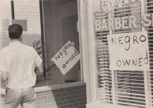 "Negro owned" sign in barbershop window during Watts rebellion, Los Angeles, August 1965