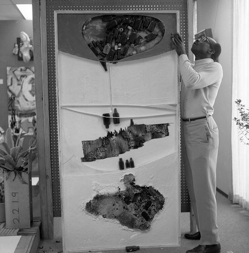 Noah Purifoy installing "66 Signs of Neon" exhibition at University of Southern California, Los Angeles, c. 1966