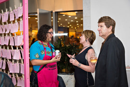 An attendant speaks to guests next to Mónica Mayer's El tendedero (The clothesline) at the opening of Radical Women. Hammer Museum, Los Angeles, September 16, 2017
