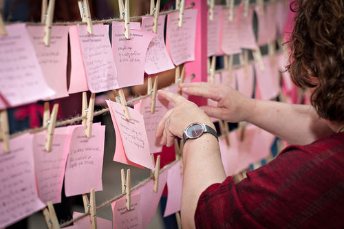 A guest hangs a card for Mónica Mayer's El tendedero (The clothesline) at the opening of Radical Women. Hammer Museum, Los Angeles, September 16, 2017
