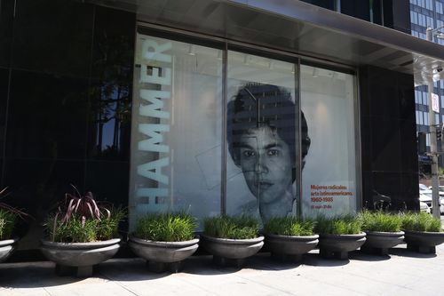 Photograph of window signage for Radical Women, featuring Liliana Porter, Untitled (self-portrait with square), 1973. Hammer Museum, Los Angeles