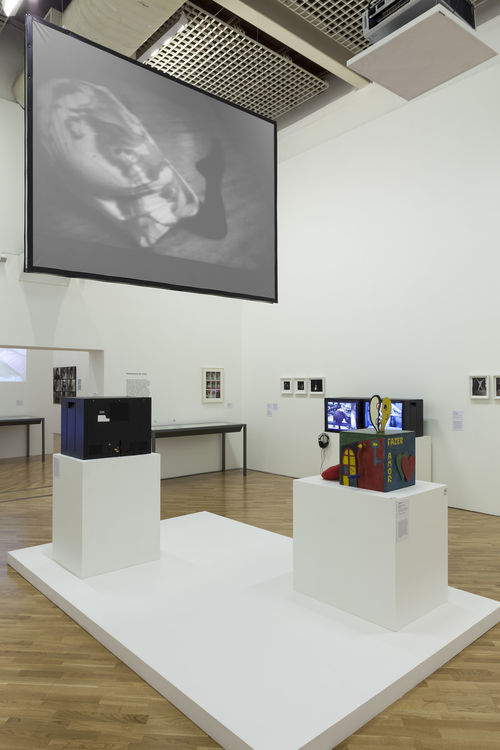 O erótico (The Erotic)/Performance do corpo (Performing the Body) gallery. Projected above: Teresa Trujillo, Improvisación danza-cine II (Improvisation dance-cinema II), 1964–65; on pedestal, at right: Teresinha Soares, Caixa de fazer amor (Lovemaking Box), 1967. Installation view at Pinacoteca de São Paulo
