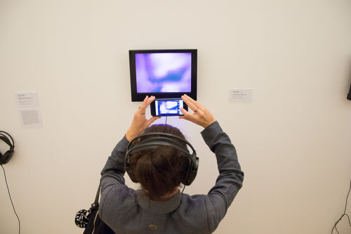 A guest photographing Patssi Valdez's Hot Pink (1980) during the opening of Radical Women. Pinacoteca de São Paulo, August 18, 2018