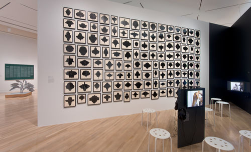 On wall: Allan McCollum, "Collection of One Hundred and Twenty Drawings," 1989/93; on monitors, from left to right: Renée Green, "Partially Buried," 1996, and Nayland Blake, "Gorge," 1998; in next gallery: works by Nayland Blake and Tom Burr. Installation view at the Hammer Museum, Los Angeles