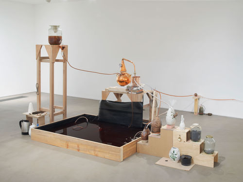 Candice Lin, System for a Stain, 2016. Wood, glass jars, cochineal, poppy seeds, metal castings, water, tea, sugar, copper still, hot plate, ceramic vessels, mortar and pestle, Thames mud, jar, microbial mud battery, vinyl floor. Dimensions variable. Commissioned by Gasworks, London. Courtesy the artist and Ghebaly Gallery, Los Angeles. Photo: Andy Keate.