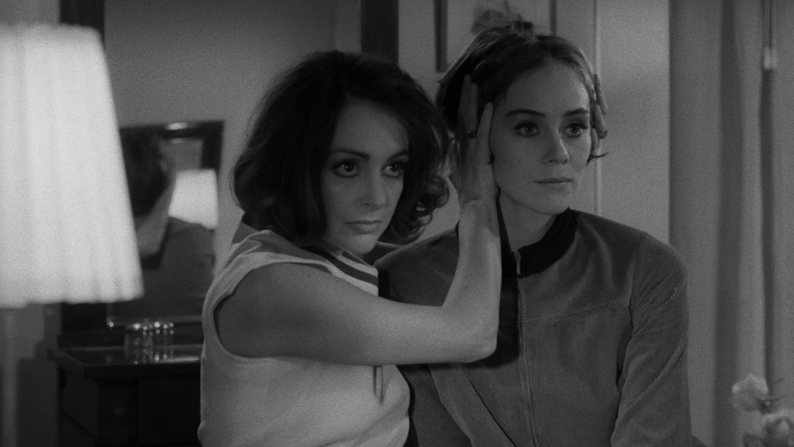 Still from the film Duet for Cannibals (1969) showing a woman holding another woman's head as they both look forward