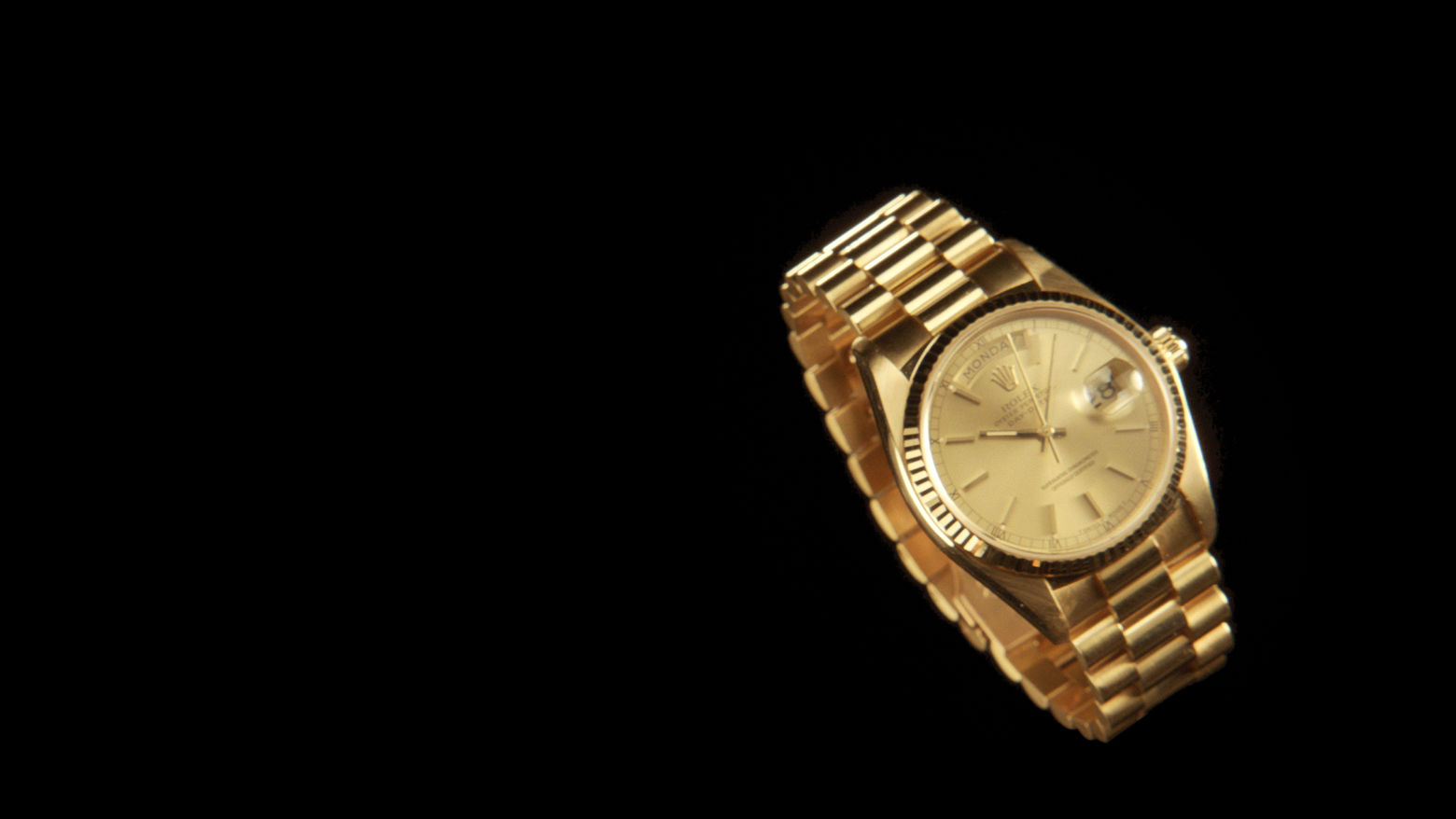 A gold watch on a black background