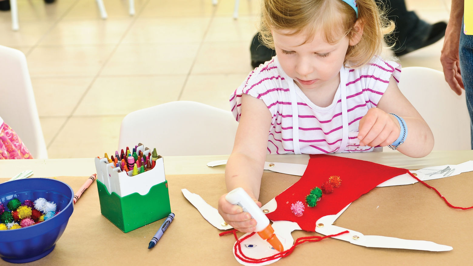 A child sits at a table crafting