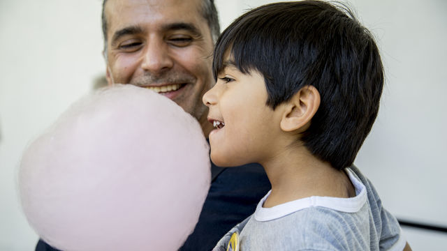 Boy smiling and eating candy floss