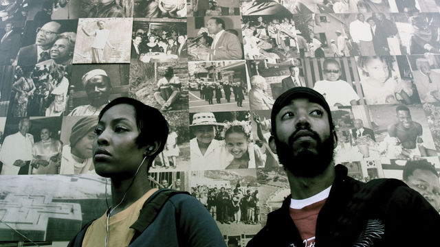 A man and a woman stand in front of a wall