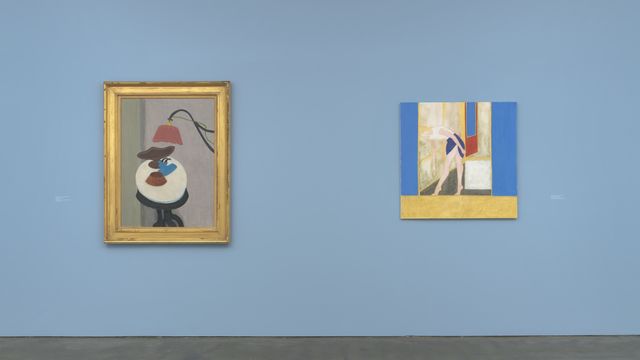 Two paintings hang on a blue gallery wall
