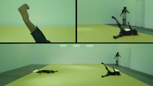 A rectangular image is divided into three segments. The bottom segment spans the full width and depicts three figures wearing dark clothes in a room with a yellow floor. Two figures lie on the floor and the third stands against the back wall. On the upper left, an arm extends into the frame, with the hand lightly cupped. The image in the upper right shows an detail of the image at bottom, showing the two figures on the right end of that image.