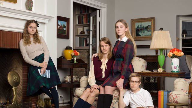 A family portrait of four preteens, arranged in a living room