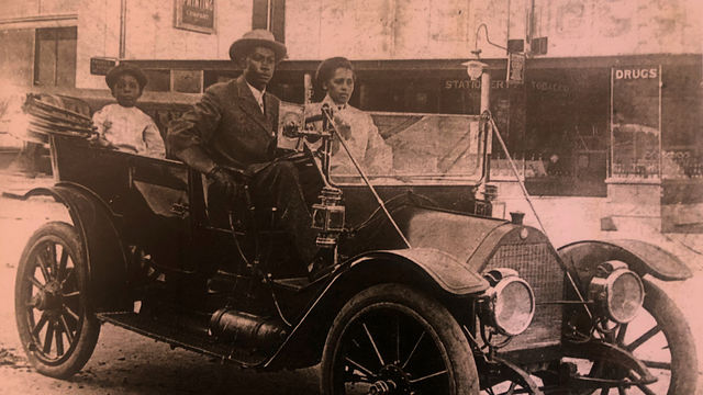 A vintage photograph of a Black family in a car