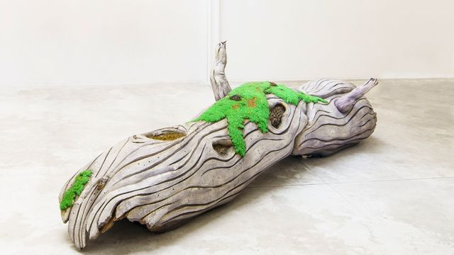 Sculpture of a pale log with bright green moss