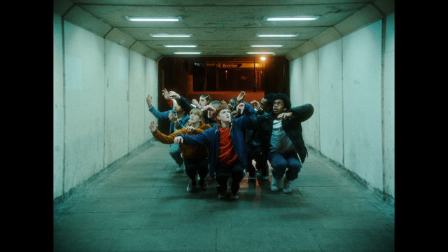 Still from the music video for "Butterflies" by Skrillex ft Starrah & Four Tet, showing a group of dancers crouched in a tunnel