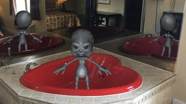 Alien in a bath tub shaped like a heart.