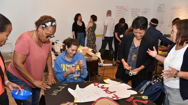 A group of teachers talk casually while working on a crafting activity