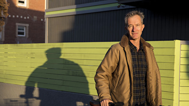 Photo portrait of author Geoff Dyer with a bicycle