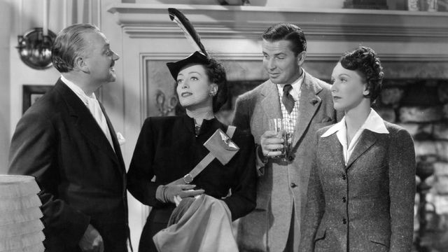 Two men and two women stand talking.
