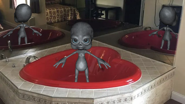 Alien in a bath tub shaped like a heart.